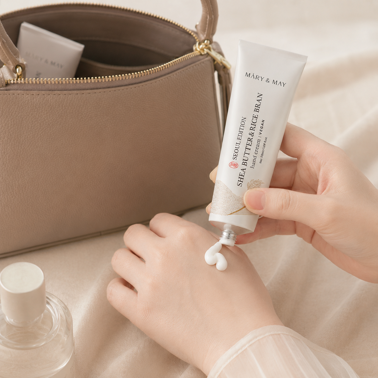 Mary & May Shea Butter & Rice Bran hand cream being applied from a tube